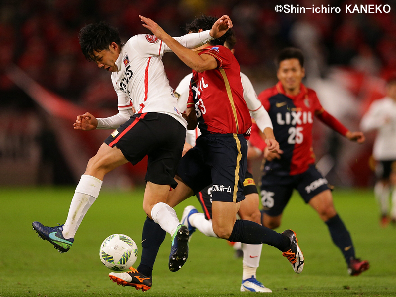 激しい守備で金崎（中央、33番）を封じた　[写真]＝兼子愼一郎